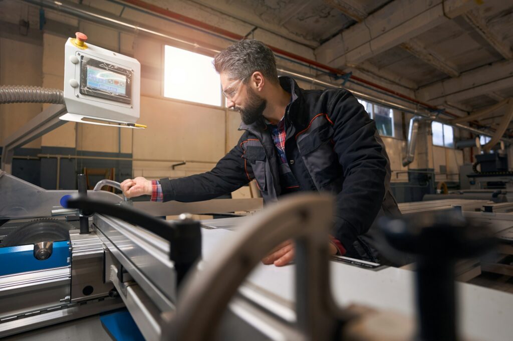 Adult man working with wood, checking quality of material