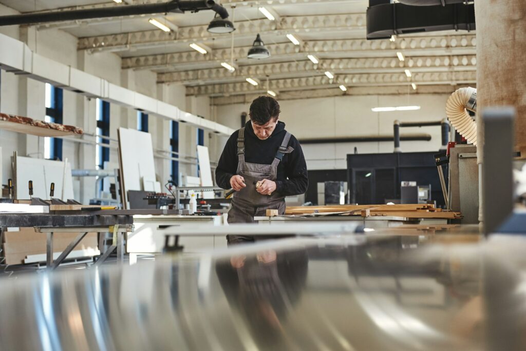 Quality Begins on the Inside. Carpenter using chisel to carve wood in workshop